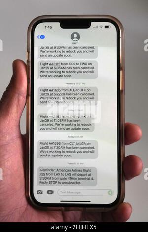 Le cancellazioni dei voli di American Airlines verso gli aeroporti della zona di New York, John F. Kennedy (JFK) e LaGuardia (LGA), in mezzo a una tempesta invernale bufera di neve e vento vengono visualizzate in messaggi di testo su un iPhone 13 Pro Max, sabato 29 gennaio 2022, a Los Angeles. Foto Stock
