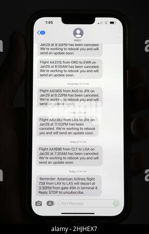Le cancellazioni dei voli di American Airlines verso gli aeroporti della zona di New York, John F. Kennedy (JFK) e LaGuardia (LGA), in mezzo a una tempesta invernale bufera di neve e vento vengono visualizzate in messaggi di testo su un iPhone 13 Pro Max, sabato 29 gennaio 2022, a Los Angeles. Foto Stock