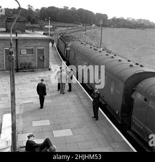 1963: Foto di archivio datata 1963 agosto degli allenatori del treno coinvolti nella rapina postale di £2,5 milioni - il 'Grande Robbery treno' - sotto la guardia di polizia a Cheddington Station, Buckinghamshire. Data di emissione: Domenica 30 gennaio 2022. Foto Stock