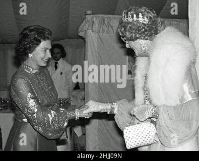 Foto di archivio datata 29/5/1977 della regina Elisabetta II riunione Dame Edna everage - la creazione dell'umorista australiano Barry Humphries - a Windsor, Quando fu tra le star che apparivano nella rappresentazione di gala nella Grande vetta di Home Park in aiuto dell'appello del Giubileo d'Argento della Regina. Data di emissione: Domenica 30 gennaio 2022. Foto Stock