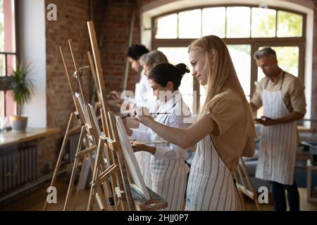 Gruppo multietnico di studenti della scuola d'arte che disegnano in pitture Foto Stock