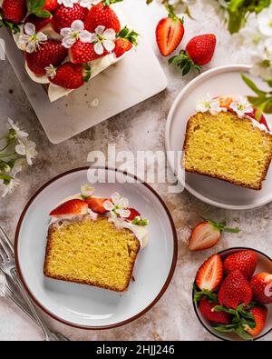 Torta estiva con fragole e formaggio cremoso su tavola di marmo bianco. Dessert estivo fatto in casa con decorazioni primaverili. Idee per il brunch. Dessert pasquale. Foto Stock