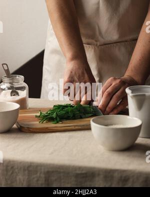 Spicchio di preparazione aglio selvatico salsa di pesto italiano con parmigiano e pinoli. Stile di vita fatto in casa concetto Foto Stock