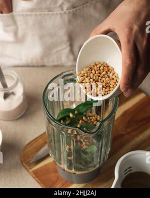 Spicchio di preparazione aglio selvatico salsa di pesto italiano con parmigiano e pinoli. Stile di vita fatto in casa concetto Foto Stock