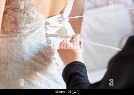 La femmina aiuta una sposa a prepararsi per il matrimonio Foto Stock
