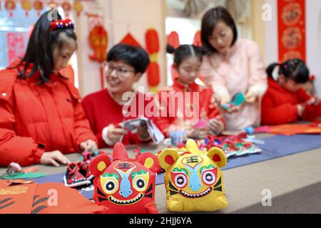 Pechino, provincia cinese di Zhejiang. 23rd Jan 2022. Gli studenti imparano a fare scarpe da tigre in un centro comunitario nella cittadina di Leidian della Contea di Deqing, Huzhou City, provincia di Zhejiang della Cina orientale, 23 gennaio 2022. Credit: Yao Haixiang/Xinhua/Alamy Live News Foto Stock