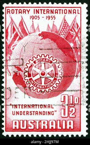AUSTRALIA - CIRCA 1955: Un francobollo stampato in Australia mostra globo, bandiere e emblema Rotary International, 50th anni, circa 1955 Foto Stock