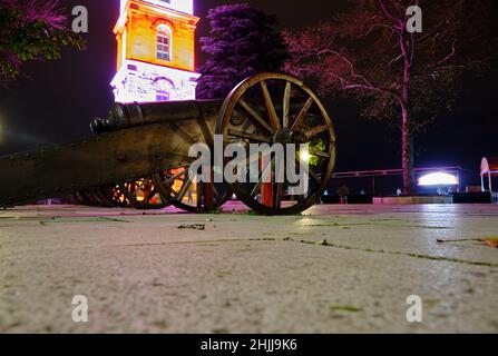 Foto notturna a Bursa, piazza Tophane, antica pistola foto ad angolo basso della torre dell'orologio illuminata. Foto Stock