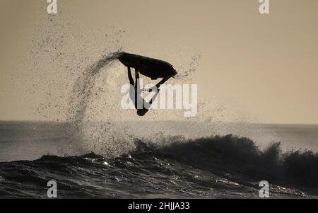 Un jet skier salta le onde al largo della costa di Blyth nel Northumberland. Data foto: Domenica 30 gennaio 2022. Foto Stock