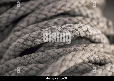 Corda grovigliata spessa in primo piano. Primo piano di una vecchia corda per imbarcazioni usurata come sfondo nautico. Foto Stock