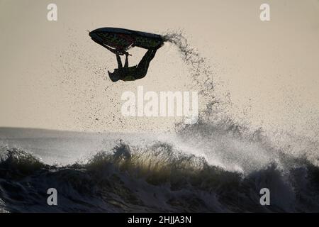 Un jet skier salta le onde al largo della costa di Blyth nel Northumberland. Data foto: Domenica 30 gennaio 2022. Foto Stock