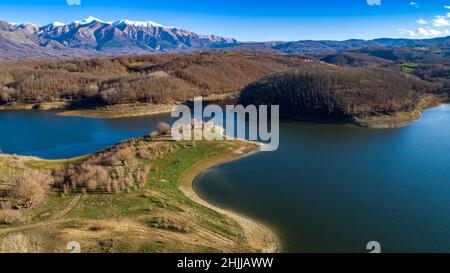 Veduta aerea del lago di scandarello ad Amatrice, Italia. Paesaggio autunnale con lago, foresta e montagne con cime innevate sullo sfondo. Foto Stock