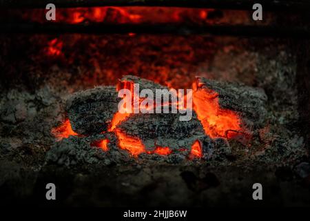 Incandescente braci in un fuoco di legno su un camino Foto Stock