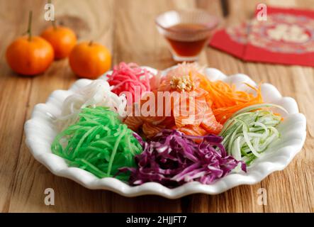 Sushi giapponese Yu Sheng. Chinese New Year Salmon Prosperity Toss on Wooden background Foto Stock