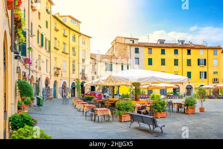 Cafe nell'accogliente piazza illuminata di mattina della vecchia città europea. Foto Stock