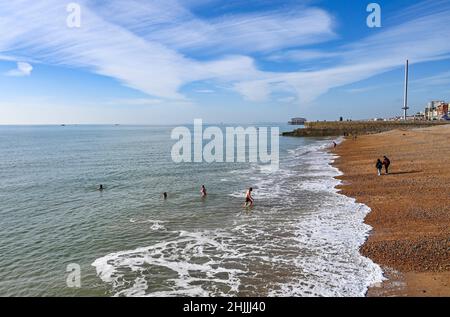 Brighton UK 30th January 2022 - i nuotatori godono di una bella giornata di sole sulla spiaggia di Brighton mentre Storm Corrie si dirige verso il nord della Gran Bretagna con un avvertimento color ambra emesso per alcune parti : Credit Simon Dack / Alamy Live News Foto Stock