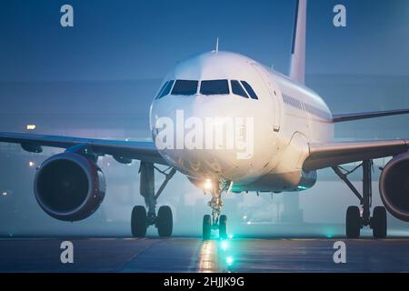 Vista frontale dell'aeroplano all'aeroporto di notte. Aereo durante la taxiing alla pista per decollo. Foto Stock