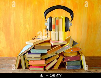 il concetto di audiolibro, con una pila di libri e cuffie vintage. Podcasting, istruzione, concetto di libro digitale. Foto Stock