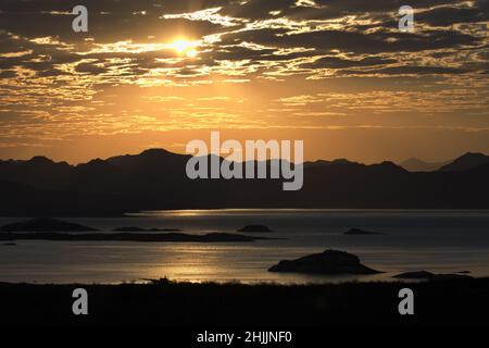 Bagliore d'oro dell'alba sopra il lago Mead, un serbatoio nel paesaggio impressionante del sud-ovest degli Stati Uniti Foto Stock
