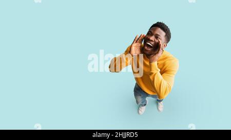 Allegro ragazzo nero che dice qualcosa fuori forte, spazio di copia Foto Stock