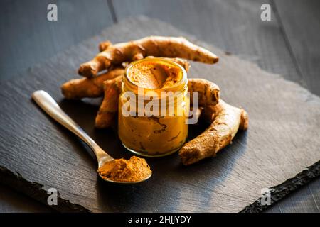 pasta di curcuma con radice di curcuma, ingrediente della medicina ajurvedica latte d'oro Foto Stock