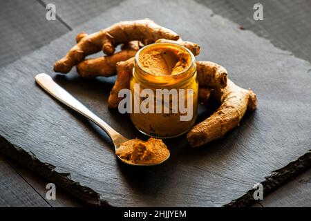 pasta di curcuma con radice di curcuma, ingrediente della medicina ajurvedica latte d'oro Foto Stock