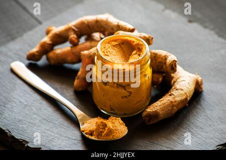 pasta di curcuma con radice di curcuma, ingrediente della medicina ajurvedica latte d'oro Foto Stock