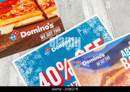 Volantini di marketing diretto di Domino's Pizza UK dalla casella di posta e con il logo di Domino. Per l'ordinazione di alimenti da asporto Covid. Foto Stock