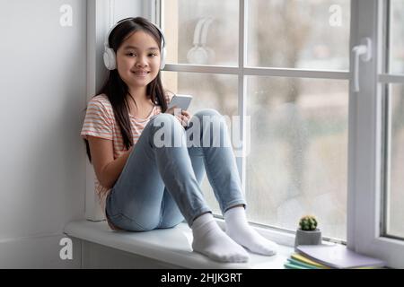 Bella ragazza coreana scolarista passare il tempo da solo a casa Foto Stock