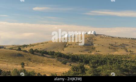 Vista dall'alto degli edifici a cupola bianca degli osservatori sulla collina. Scatto. Strutture di ricerca astronomica e grandi osservatori situati in cima con belle Foto Stock