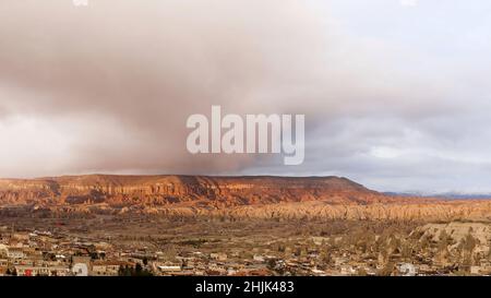 Vista aerea dal drone di montagne e rocce in Cappadocia vicino Goreme, Turchia. Azione. Bella valle rocciosa con case su sfondo cielo nuvoloso Foto Stock