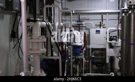 Installazione del sistema nel locale pompe. Scena. Tubi in un locale caldaie. Riscaldamento acqua. Alimentazione. Alimentazione idrica. Moderne attrezzature per la sala caldaie. Potenza b elevata Foto Stock