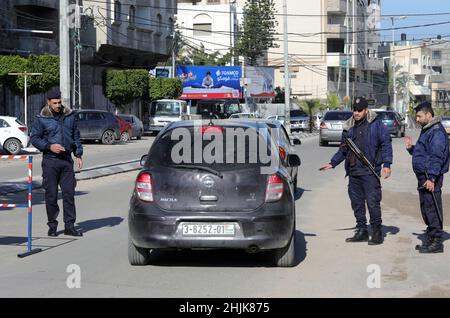 Gaza, Palestina. 30th Jan 2022. Gli ufficiali di polizia palestinesi ispezionano un'auto in un checkpoint nel mezzo della città di Gaza.le forze di sicurezza fedeli ad Hamas nella striscia di Gaza sono state dispiegate intensamente dopo che il portavoce del ministero degli interni nella striscia di Gaza Iyad al Bozom ha annunciato che un detenuto di sicurezza ha collaborato con Israele chiamato Abd Al-Karim Shaaban Abu Odeh 35 anni sono fuggiti da una delle più grandi prigioni della città di Gaza e le forze di sicurezza stanno conducendo molte misure per riarrestarlo. Credit: SOPA Images Limited/Alamy Live News Foto Stock