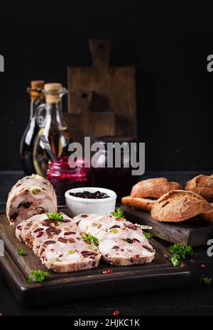 Deliziosa terrina di carne con pollo a fette, piselli verdi e frutta secca. Polpettone. Foto Stock