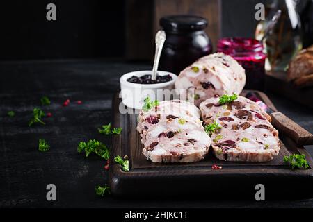 Deliziosa terrina di carne con pollo a fette, piselli verdi e frutta secca. Polpettone. Foto Stock