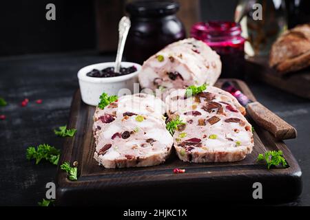 Deliziosa terrina di carne con pollo a fette, piselli verdi e frutta secca. Polpettone. Foto Stock