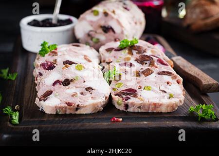 Deliziosa terrina di carne con pollo a fette, piselli verdi e frutta secca. Polpettone. Foto Stock