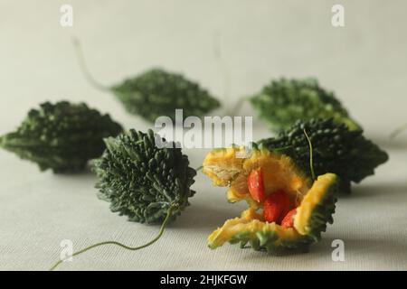 La zucca amara, nota anche come pavakka o karela, è una vite tropicale che appartiene alla famiglia delle zucche dal gusto amaro. Ripresa su sfondo bianco con evidenziazione Foto Stock