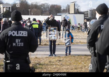 Monaco, Germnay. 30th Jan 2022. Partecipante con il bambino e firma 'lasciate i bambini essere bambini' e 'chiedere fuori' dietro la polizia. Il 30 gennaio 2022, a Monaco di Baviera, in Germania, centinaia di antivasseri si sono riuniti al Theresienwiese per dimostrare di essere contrari alla vaccinazione obbligatoria e alle misure del Covid. (Foto di Alexander Pohl/Sipa USA) Credit: Sipa USA/Alamy Live News Foto Stock