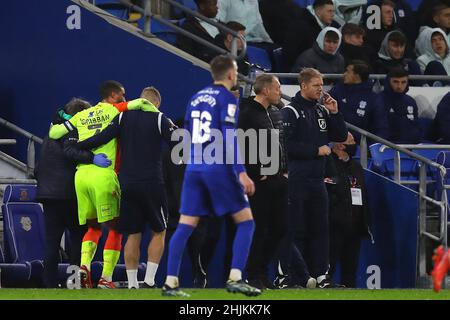 Cardiff, Regno Unito. 30th Jan 2022. Lewis Graban di Nottingham Forest è preso di feriti come Steve Cooper, il Nottingham Forest manager (2nd r) e il suo assistente Alan Tate guardare sopra. EFL Skybet Championship Match, Cardiff City contro Nottingham Forest al Cardiff City Stadium di Cardiff, Galles, domenica 30th gennaio 2022. Questa immagine può essere utilizzata solo a scopo editoriale. Solo per uso editoriale, licenza richiesta per uso commerciale. Nessun uso in scommesse, giochi o un singolo club / campionato / giocatori pubblicazioni. pic di Andrew Orchard / Andrew Orchard sport fotografia / Alamy Live news Foto Stock