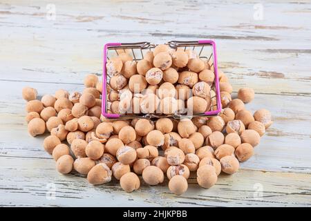 Arachidi di salsa di soia in una ciotola di legno. Arachidi arrosto ricoperte di salsa di soia Blend. Arachidi cracked con salsa di soia. Foto Stock