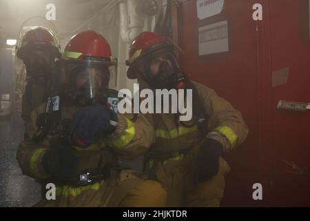 MAR DELLE FILIPPINE (Gen. 22, 2022) i marinai combattono un fuoco simulato durante una perforazione generale a bordo della portaerei di classe Nimitz USS Abraham Lincoln (CVN 72). Operando come parte della flotta statunitense del Pacifico, le unità assegnate ai gruppi Carl Vinson e Abraham Lincoln Carrier Strike, America e Essex Amphibious Ready Groups, insieme alla Japan Maritime Self-Defense Force, stanno conducendo corsi di formazione per preservare e proteggere una regione indopacifica libera e aperta. Foto Stock