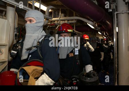 MAR DELLE FILIPPINE (Gen. 22, 2022) i marinai si preparano a combattere un incendio simulato durante una perforazione generale a bordo della portaerei di classe Nimitz USS Abraham Lincoln (CVN 72). Operando come parte della flotta statunitense del Pacifico, le unità assegnate ai gruppi Carl Vinson e Abraham Lincoln Carrier Strike, America e Essex Amphibious Ready Groups, insieme alla Japan Maritime Self-Defense Force, stanno conducendo corsi di formazione per preservare e proteggere una regione indopacifica libera e aperta. Foto Stock