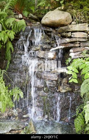 piccolo ruscello che scorre lungo pareti rocciose piccola cascata costruita da materiali locali rydal lake district, cumbria, inghilterra, regno unito Foto Stock