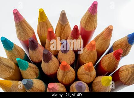 Matite colorate in legno affilate su sfondo bianco. Foto Stock