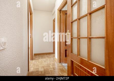 Corridoio residenziale con porte in legno color mogano e vetro Foto Stock