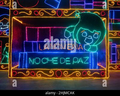 Medellin, Antioquia, Colombia - Gennaio 4 2022: Decorazione infantile di luci colorate con un cartello 'Novena, Notte della Pace' Foto Stock