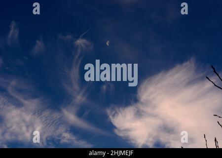 Una luna dell'ultimo quarto, a volte chiamata mezzaluna, condivide il cielo con le nubi di cirro spia sopra Santa Fe, New Mexico. Foto Stock