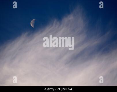 Una luna dell'ultimo quarto, a volte chiamata mezzaluna, condivide il cielo con le nubi di cirro spia sopra Santa Fe, New Mexico. Foto Stock