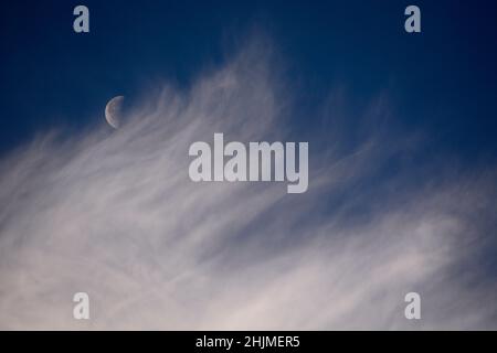 Una luna dell'ultimo quarto, a volte chiamata mezzaluna, condivide il cielo con le nubi di cirro spia sopra Santa Fe, New Mexico. Foto Stock